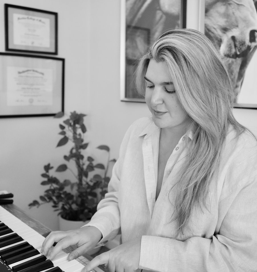 Christina at the piano, seated at home.